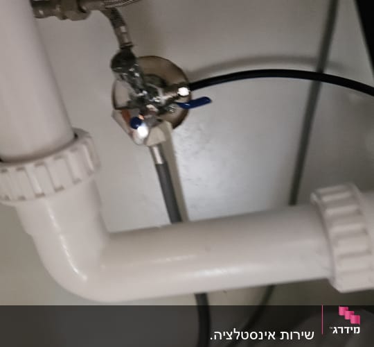 צינורות מתחת לכיור עם ברזים וחיבורים